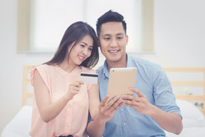Couple looking at table holding credit card
